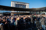 Menschenmenge vor dem Grazer Hauptbahnhof. Im Hintergrund das Bahnhofsgebäude an einem sonnigen Tag.